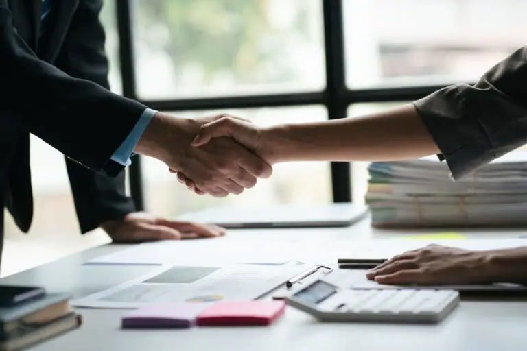 Close up view of business people shaking hands together after the deal was successful.